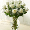 A Dozen Long Stemmed Rose Arrangement In A Glass Urn/Vase With Greenery
